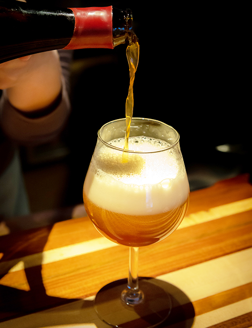 beer being poured into glass in bar